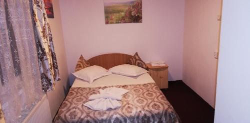 a small bedroom with a bed with two pillows at Cabana Moieciu in Moieciu de Sus