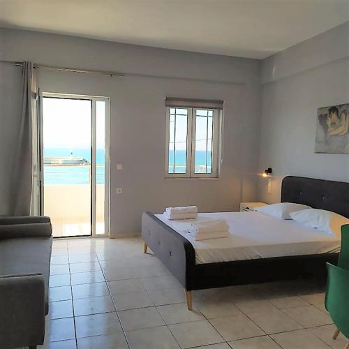 a bedroom with a bed and a view of the ocean at Sole Mare Seaside Apartments in Gouves