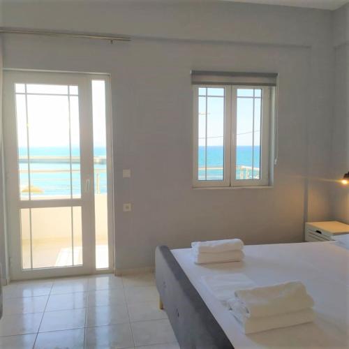 a bedroom with a bed with a view of the ocean at Sole Mare Seaside Apartments in Gouves