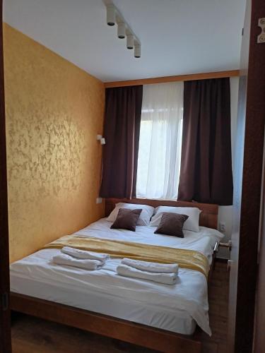 a bedroom with a bed with two towels on it at Apartmani Vidatela Kopaonik in Kopaonik