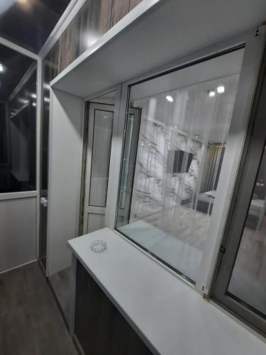 a bathroom with a white counter and a window at Люкс академика сатпаева 19 in Pavlodar