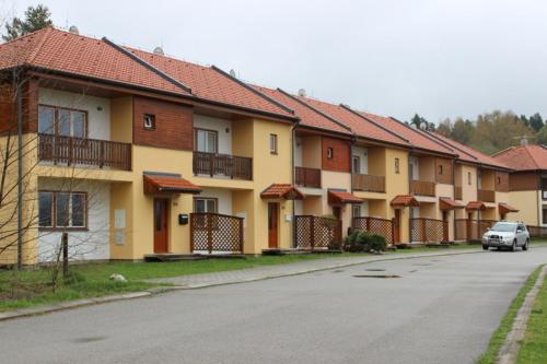 a row of houses with a car parked on the street at Holiday House - Orange Antik 112 Lipno Home in Lipno nad Vltavou