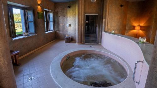 a large bathroom with a tub with water in it at Relais Bella Rosina Pool & Spa in Fiano