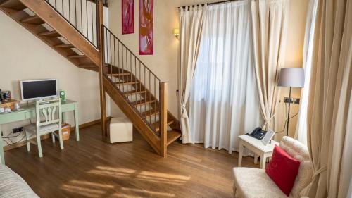 a living room with a staircase and a desk at Relais Bella Rosina Pool & Spa in Fiano