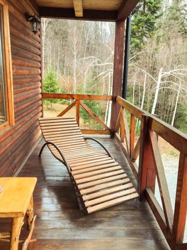 a porch of a cabin with a bench and a table at Dachna Sadyba PB in Migovo