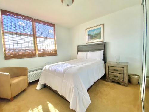 a bedroom with a large white bed and a chair at COSTA BRAVA 23 in Ceiba