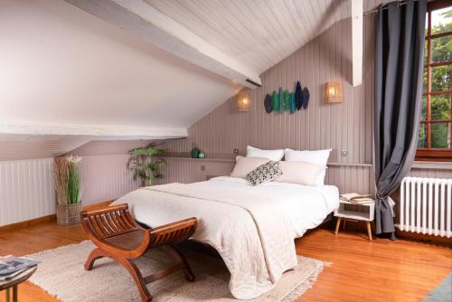 a bedroom with a large bed and a chair at Les Glycines de Monchy- Chambres d'hôtes in Monchy-Humières