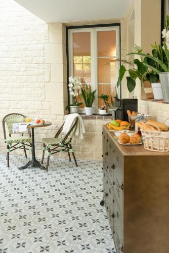 a kitchen with a tile floor with a table and chairs at Les Glycines de Monchy- Chambres d'hôtes in Monchy-Humières