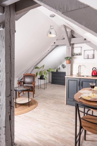an open kitchen and living room with tables and chairs at Les Glycines de Monchy- Chambres d'hôtes in Monchy-Humières