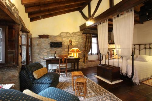 un soggiorno con letto e scrivania in una camera di Hotel Casona D'Alevia ad Alevia
