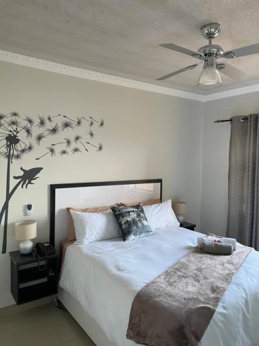 a bedroom with a bed with birds on the wall at Mohlakeng Guest House in Randfontein