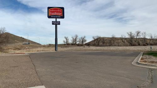 an empty parking lot with a sign in the middle at Fairbridge Inn and Suites - Miles City in Miles City