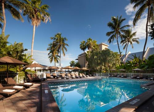 a pool at the resort with chairs and palm trees at Pier House Resort & Spa in Key West