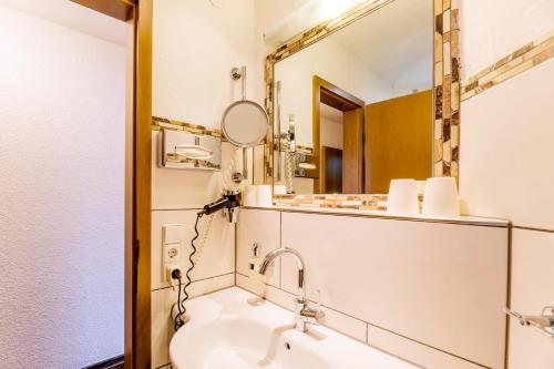 a bathroom with a sink and a mirror at Hotel Engel - Familotel Hochschwarzwald in Todtnauberg