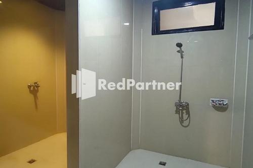 a bathroom with a toilet and a mirror on the wall at Hotel Abna Sangatta Mitra RedDoorz in Sengata