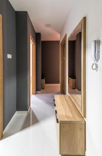 a hallway with a wooden bench and a mirror at Daisy resort in Novi Sad
