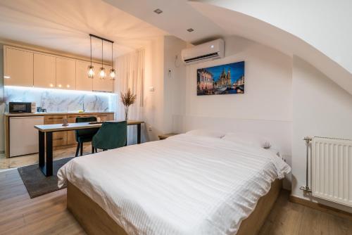 a bedroom with a white bed and a desk at Daisy resort in Novi Sad
