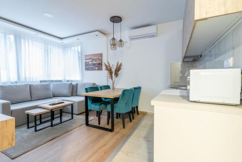 a kitchen and living room with a table and a couch at Daisy resort in Novi Sad