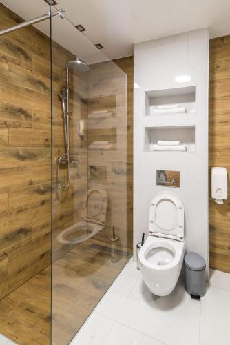 a bathroom with a toilet and a glass shower at Daisy resort in Novi Sad