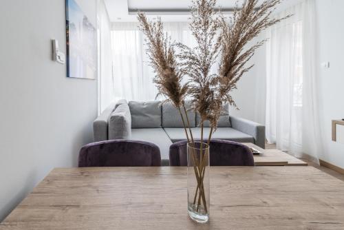 a table with a vase with some plants in it at Daisy resort in Novi Sad