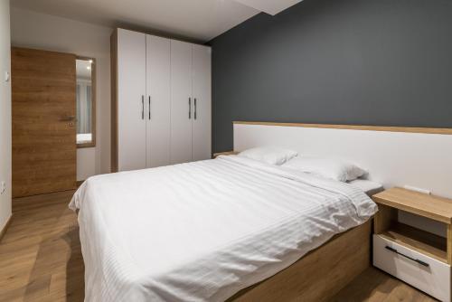 a bedroom with a large bed with white sheets at Daisy resort in Novi Sad