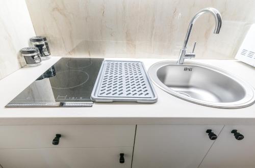 a kitchen counter with a sink and a faucet at Daisy resort in Novi Sad