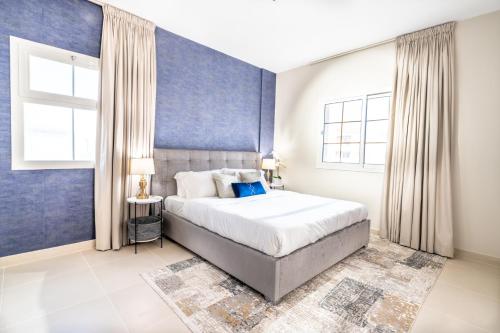 1 dormitorio con cama y pared azul en Mabaat - Al Waha 5 - 243, en King Abdullah Economic City