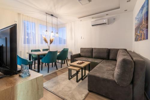 a living room with a couch and a dining room at Daisy resort in Novi Sad
