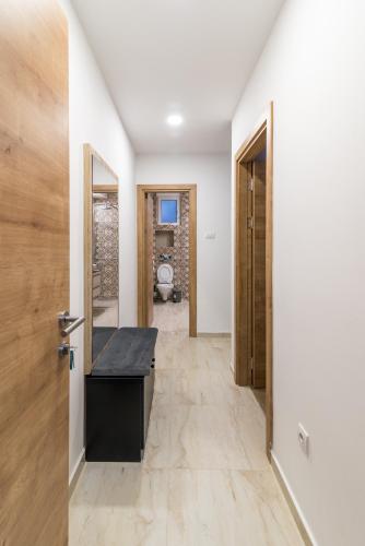 a hallway with white walls and a door with a desk at Daisy resort in Novi Sad