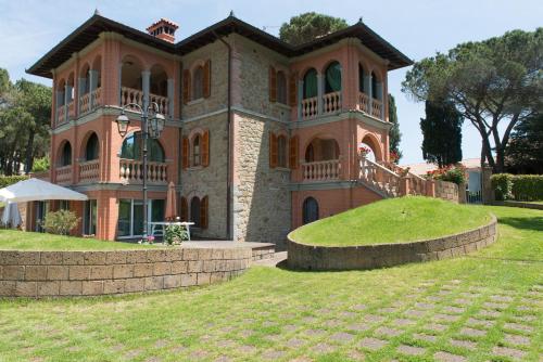 uma casa grande com um jardim relvado à frente em San Bartolomeo Suite em Castel Rigone