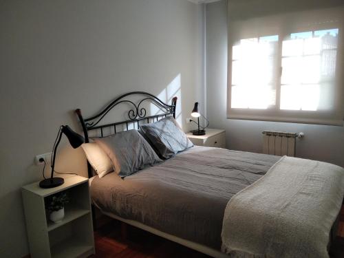 Un dormitorio con una cama grande y una ventana en JARDINES DE VINJOY, en Oviedo