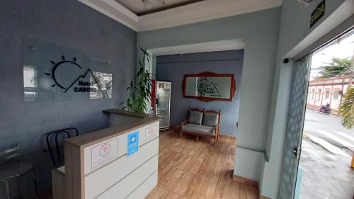 uma sala de estar com paredes azuis e uma mesa e uma cadeira em Hotel Cadore em Bauru