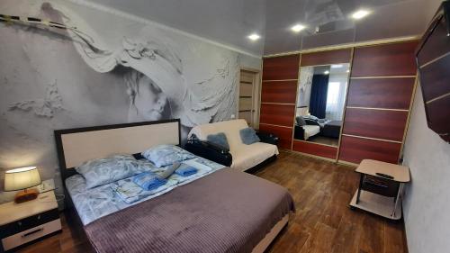 マグニトゴルスクにあるApartments na Lenina 124のベッドルーム(ベッド1台、鏡付)