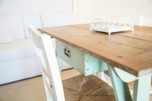 a wooden table with a white chair next to it at Podere Santa Chiara in Otranto