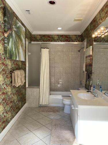a bathroom with a tub and a sink and a toilet at Paradise Found - Private Oasis with Heated Pool on Marco Island in Marco Island