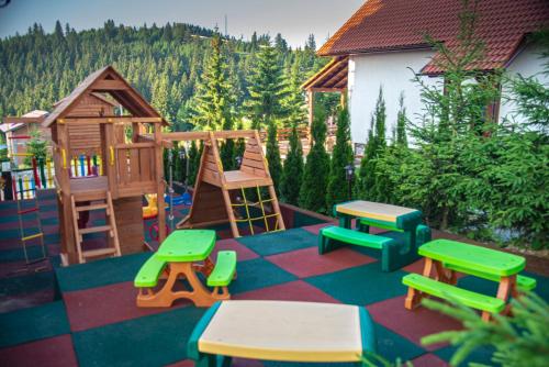 a childrens play area with a wooden playground at Pensiune Rara Paltinis in Păltiniş