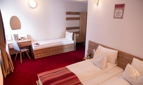 a hotel room with two beds and a desk and a desk at Pensiune Rara Paltinis in Păltiniş