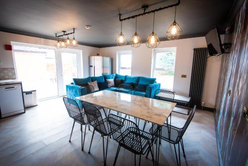 uma sala de estar com uma mesa e cadeiras azuis em Sallow Tree House Self Catering em Selby