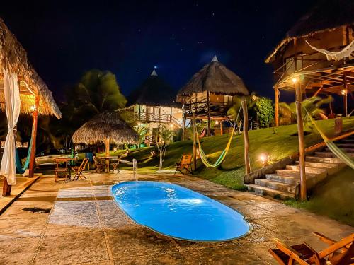 a swimming pool at a resort at night at Pousada Theodora in Macapá