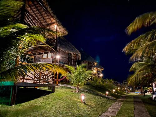 a building with palm trees in front of it at night at Pousada Theodora in Macapá