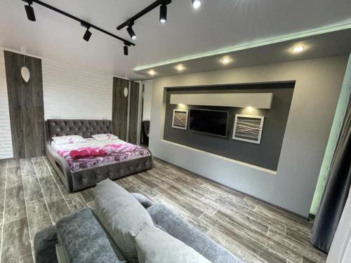 a living room with a bed and a couch at ЛЮКС академика сатпаева 47 in Pavlodar