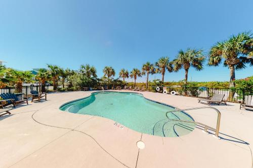 a swimming pool at a resort with palm trees at Lund - Nordic Villas in Orange Beach