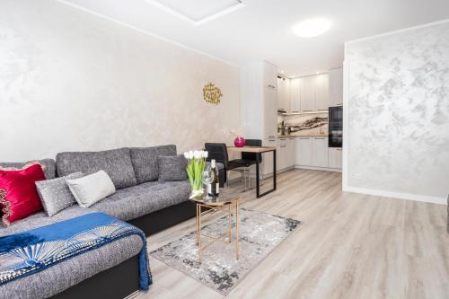 ein Wohnzimmer mit einem Sofa und einem Tisch in der Unterkunft GDAŃSK CENTRUM Stylowy Apartament in Danzig