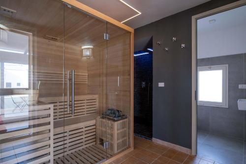 una doccia con porta in vetro in bagno di Ada Suites & Spa a Lecce