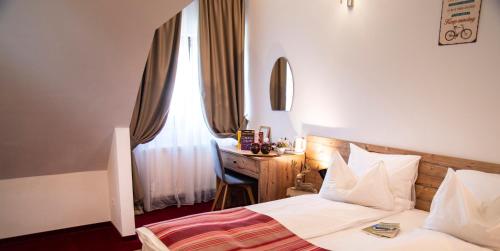 a bedroom with a bed and a desk and a window at Pensiune Rara Paltinis in Păltiniş