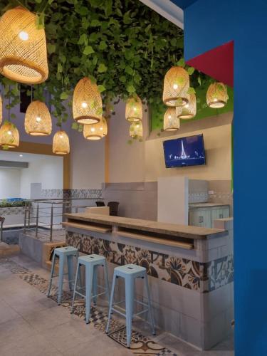 a bar in a restaurant with stools and lights at Hotel Zamay Centro Historico in Santa Marta