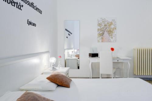 a white bedroom with a bed and a table at Ada Suites & Spa in Lecce