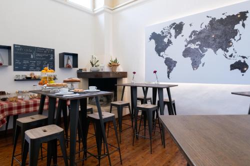 a restaurant with tables and stools with a world map on the wall at Ada Suites & Spa in Lecce