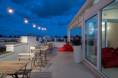 a row of tables and chairs on a balcony at night at Ada Suites & Spa in Lecce