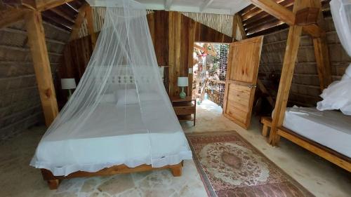 a bedroom with a bed with a mosquito net at El Valle Lodge in El Valle